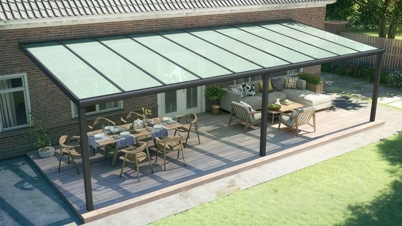 Vista dall'alto di una Veranda moderna nero 9005, dimensioni 10,06 x 3,5 metri con tetto in vetro opale. Pergola/Gazebo elegante e resistente alle intemperie, ideale per spazi esterni raffinati e confortevoli, offre protezione UV ed è facile da montare.