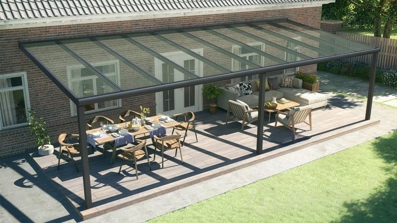 Vista dall'alto di una Veranda moderna nero 9005, dimensioni 10,06 x 3,5 metri con tetto in vetro trasparente. Pergola/Gazebo elegante e resistente alle intemperie, ideale per spazi esterni raffinati e confortevoli, offre protezione UV ed è facile da montare.