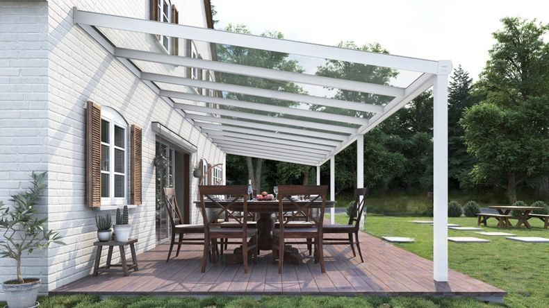Vista laterale di una Veranda moderna bianco 9016, dimensioni 12,06 x 3,5 metri con tetto in vetro trasparente. Pergola/Gazebo elegante e resistente alle intemperie, ideale per spazi esterni raffinati e confortevoli, offre protezione UV ed è facile da montare.
