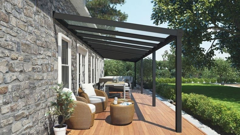 Vista laterale di una Veranda moderna nero 9005, dimensioni 12,06 x 3,0 metri con tetto in vetro trasparente. Pergola/Gazebo elegante e resistente alle intemperie, ideale per spazi esterni raffinati e confortevoli, offre protezione UV ed è facile da montare.