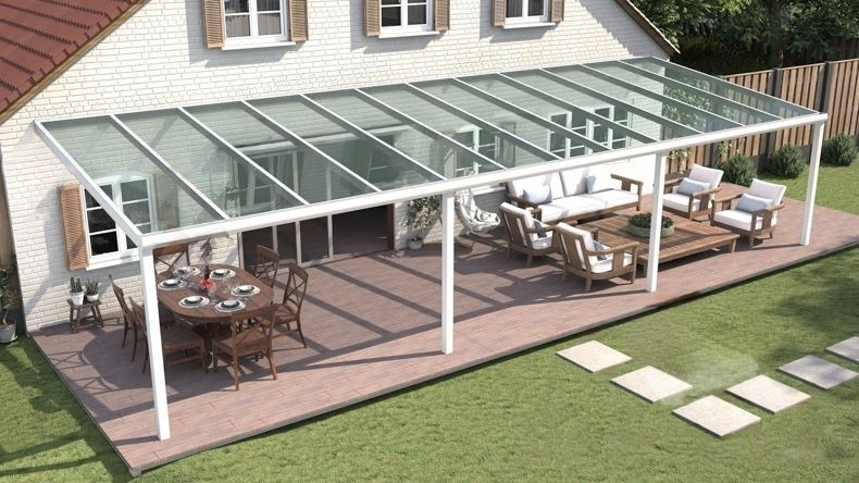 Vista dall'alto di una Veranda moderna bianco 9016, dimensioni 12,06 x 4,0 metri con tetto in vetro trasparente. Pergola/Gazebo elegante e resistente alle intemperie, ideale per spazi esterni raffinati e confortevoli, offre protezione UV ed è facile da montare.