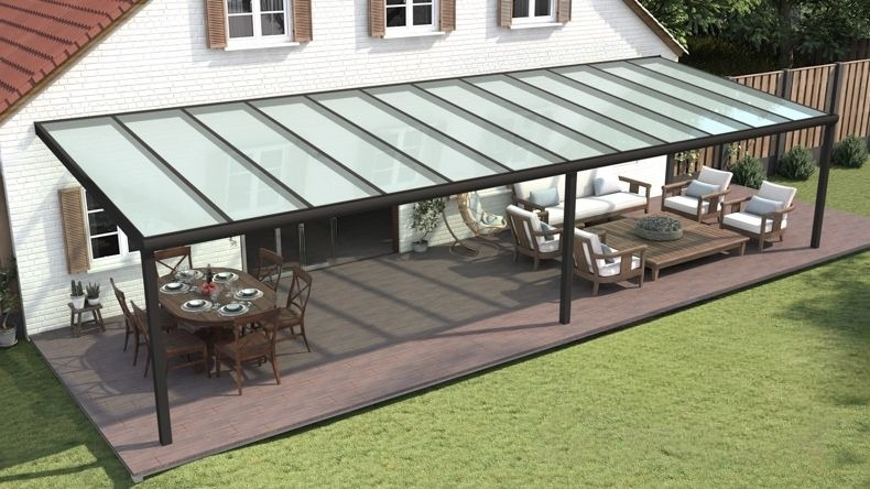 Vista dall'alto di una Veranda moderna nero 9005, dimensioni 12,06 x 4,0 metri con tetto in vetro opale. Pergola/Gazebo elegante e resistente alle intemperie, ideale per spazi esterni raffinati e confortevoli, offre protezione UV ed è facile da montare.