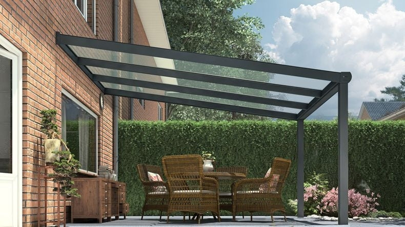 Vista laterale di una Veranda moderna antracite 7016, dimensioni 3,06 x 4,0 metri con tetto in vetro trasparente. Pergola/Gazebo elegante e resistente alle intemperie, ideale per spazi esterni raffinati e confortevoli, offre protezione UV ed è facile da montare.