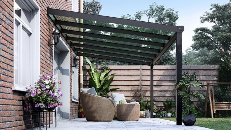 Vista laterale di una Veranda moderna antracite 7016, dimensioni 6,06 x 2,5 metri con tetto in vetro trasparente. Pergola/Gazebo elegante e resistente alle intemperie, ideale per spazi esterni raffinati e confortevoli, offre protezione UV ed è facile da montare.