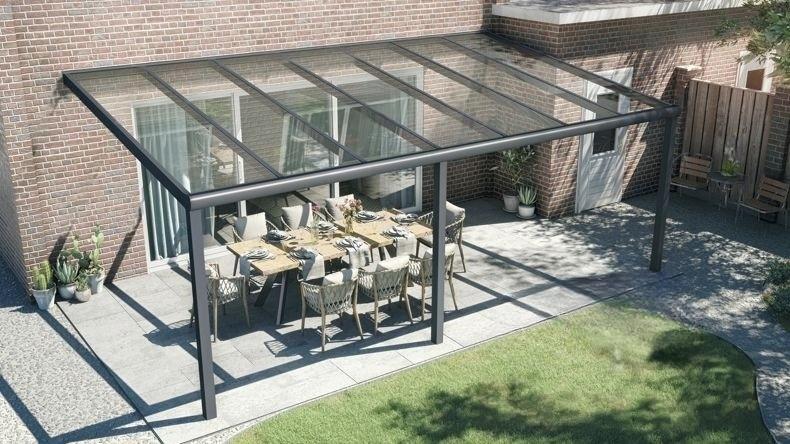 Vista dall'alto di una Veranda moderna antracite 7016, dimensioni 7,06 x 4,0 metri con tetto in vetro trasparente. Pergola/Gazebo elegante e resistente alle intemperie, ideale per spazi esterni raffinati e confortevoli, offre protezione UV ed è facile da montare.