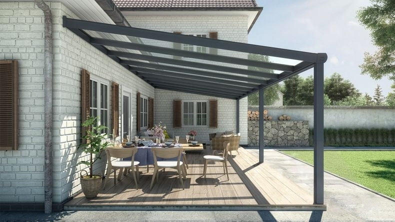 Vista laterale di una Veranda moderna antracite 7016, dimensioni 9,06 x 4,0 metri con tetto in vetro trasparente. Pergola/Gazebo elegante e resistente alle intemperie, ideale per spazi esterni raffinati e confortevoli, offre protezione UV ed è facile da montare.