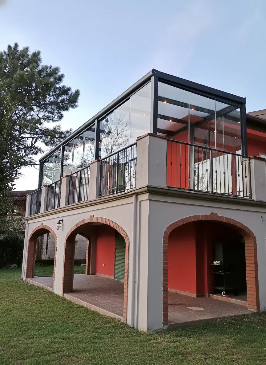 Veranda in alluminio colore antracite con chiusure in vetro e tetto in vetro opale, lunghezza 12 metri, installata su terrazza di villetta, Verande in Giardino.