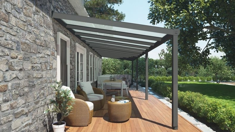 Vista laterale di una Veranda moderna antracite 7016, dimensioni 12,06 x 2,5 metri con tetto in vetro opale. Pergola/Gazebo elegante e resistente alle intemperie, ideale per spazi esterni raffinati e confortevoli, offre protezione UV ed è facile da montare.