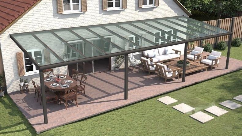 Vista dall'alto di una Veranda moderna antracite 7016, dimensioni 12,06 x 3,5 metri con tetto in vetro trasparente. Pergola/Gazebo elegante e resistente alle intemperie, ideale per spazi esterni raffinati e confortevoli, offre protezione UV ed è facile da montare.