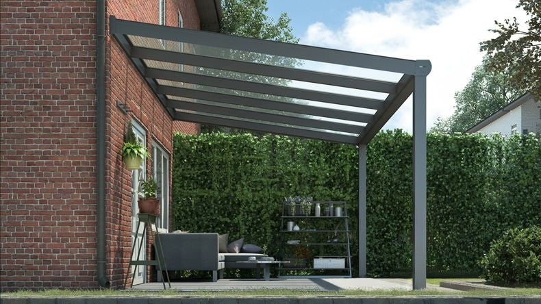 Vista laterale di una Veranda moderna antracite 7016, dimensioni 5,06 x 2,5 metri con tetto in vetro trasparente. Pergola/Gazebo elegante e resistente alle intemperie, ideale per spazi esterni raffinati e confortevoli, offre protezione UV ed è facile da montare.