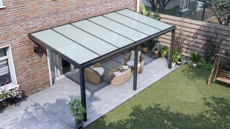 Vista dall'alto di una Veranda moderna nero 9005, dimensioni 6,06 x 2,5 metri con tetto in vetro opale. Pergola/Gazebo elegante e resistente alle intemperie, ideale per spazi esterni raffinati e confortevoli, offre protezione UV ed è facile da montare.