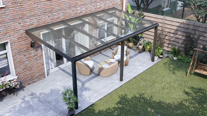 Vista dall'alto di una Veranda moderna nero 9005, dimensioni 6,06 x 3,0 metri con tetto in vetro trasparente. Pergola/Gazebo elegante e resistente alle intemperie, ideale per spazi esterni raffinati e confortevoli, offre protezione UV ed è facile da montare.