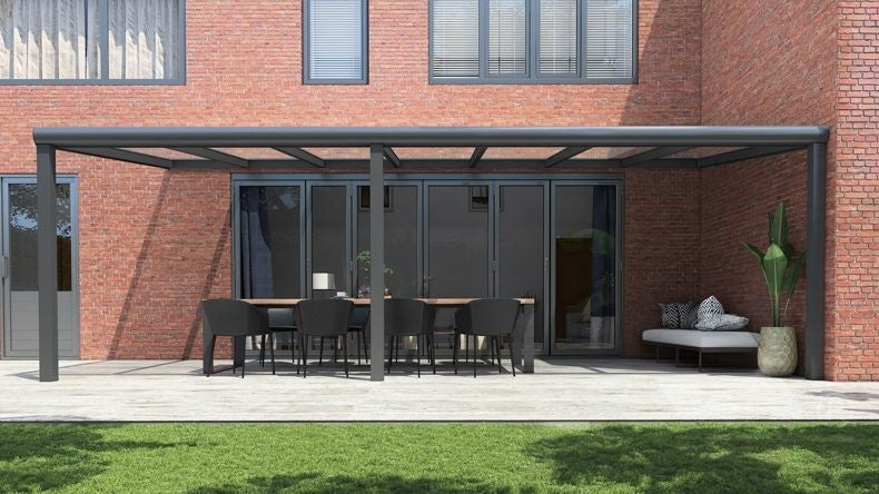 Vista Frontale di una Veranda moderna antracite 7016, dimensioni 7,06 x 2,5 metri con tetto in vetro trasparente. Pergola/Gazebo elegante e resistente alle intemperie, ideale per spazi esterni raffinati e confortevoli, offre protezione UV ed è facile da montare.