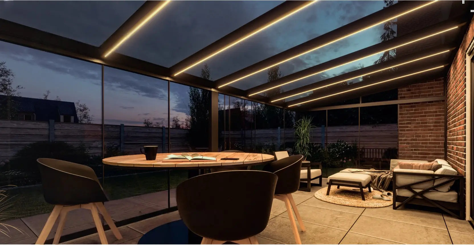 Veranda Antracite (RAL 7016) 5,06×3,5 m con tetto in Vetro Trasparente e illuminazione LED integrata, ambientata di sera con arredo moderno — Verande in Giardino